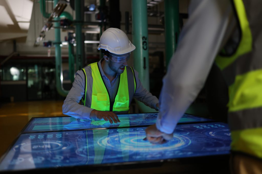 The Two Specialist Engineers Are Currently Occupied With The Task Of Working On A Highly Advanced Digital Control Panel.