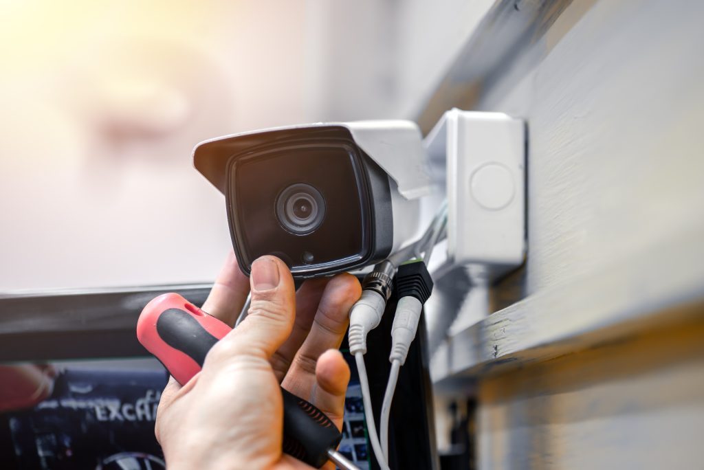 Close Up Of Surveillance Camera Installation, Male Hand Holds Cctv Camera